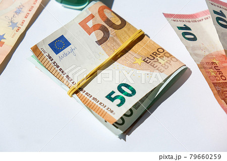 Close up of Euro money roll. Euro banknote set cash money - EU currency. Rolled with rubber euro notes. Banknotes stacked on each other in different positions 79660259