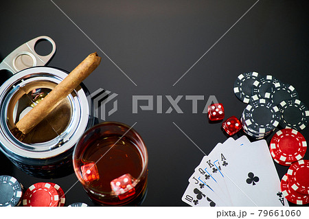 Casino chips, playing cards, glass of whiskey and dices on dark reflective background Casino chips, playing cards, glass of whiskey and dices on dark reflective background 79661060