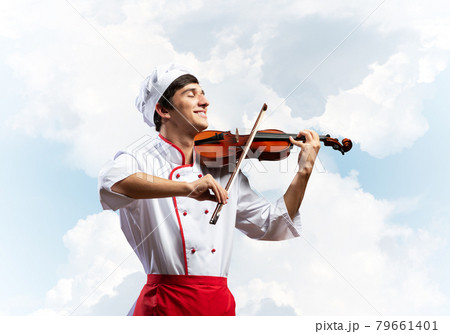Young male chef playing violin Young male chef playing violin 79661401