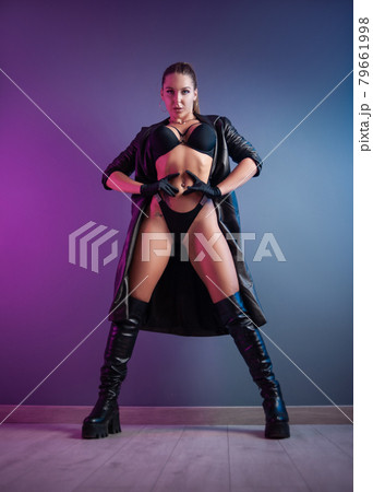 sexy woman in underwear, leather raincoat and long leather shoes in the studio on a neon background sexy woman in underwear, leather raincoat and long leather shoes in the studio on a neon background 79661998