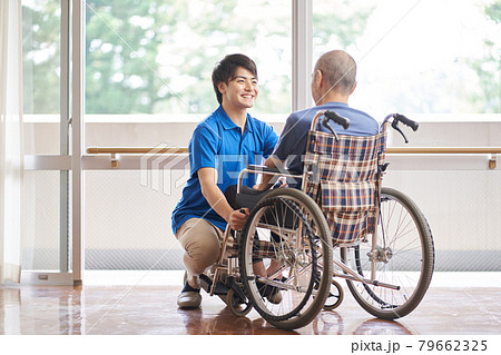 車椅子に乗る高齢者と介護士	 79662325