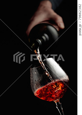 Pouring brandy in a glass goblet. 79662382