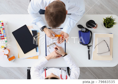 Doctor writes prescription to patient for medicine top view 79663535