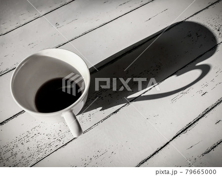 Coffee mugs on white wooden table in black and white vintage style. 79665000