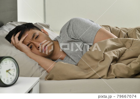 Depressed young Asian man lying in bed cannot sleep from insomnia Depressed young Asian man lying in bed cannot sleep from insomnia 79667074