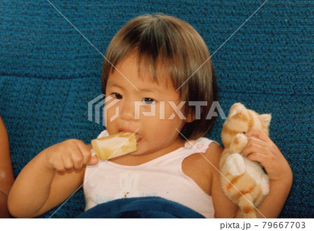 猫のぬいぐるみを持ってアイスを食べている女の子 79667703