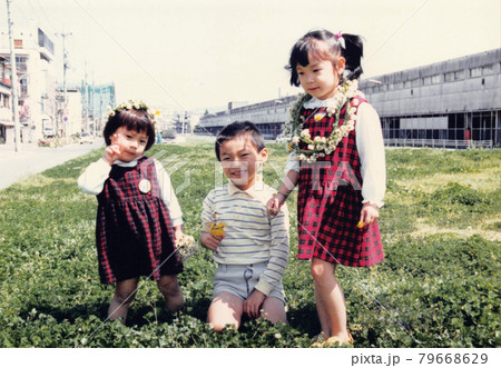 昔のフィルム写真　シロツメクサの王冠で遊ぶ子供たち 79668629