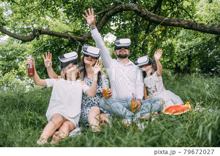 Happy family having fun in virtual glasses on fresh air Happy family having fun in virtual glasses on fresh air 79672027