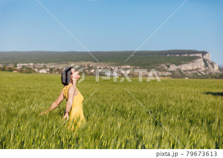 a woman in a field of green wheat before harvesting a woman in a field of green wheat before harvesting 79673613