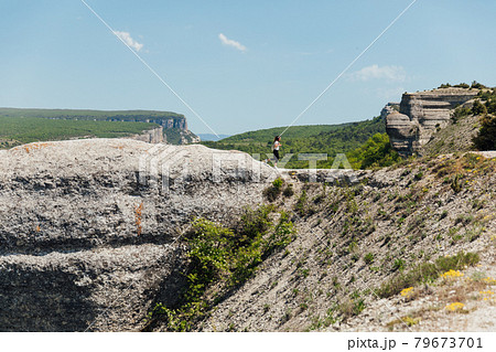 beautiful brunette woman on a cliff looking at the nature of the journey 79673701
