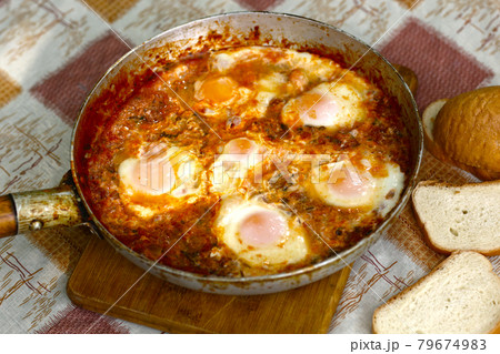 shakshuka - jewish national dish with fried eggs species, tomato, pepper garlic 79674983