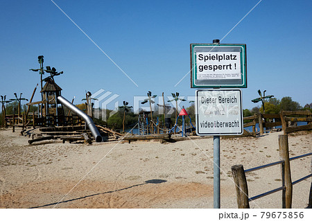 Entrance of an adventure playground with a sign with the German inscription: Spielplatz gesperrt, this area is monitored by video 79675856