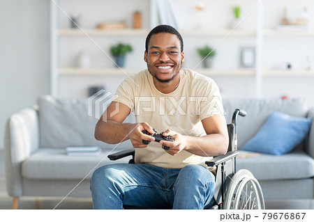 Cheerful disabled man in wheelchair enjoying videogame on playstation, having fun at home Cheerful disabled man in wheelchair enjoying videogame on playstation, having fun at home 79676867