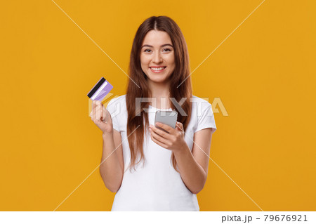 Happy young lady with smartphone and credit card 79676921