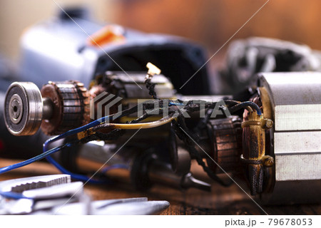 Power tool repair. Details of electrical appliance and repair tools on a wooden table in a repair shop 79678053