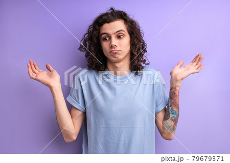 I don't know. Portrait of confused handsome young male in blue casual t-shirt standing with raised arms I don't know. Portrait of confused handsome young male in blue casual t-shirt standing with raised arms 79679371