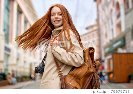 Relaxed friendly trendy young redhead woman traveler with warm smile take photo Relaxed friendly trendy young redhead woman traveler with warm smile take photo 79679712