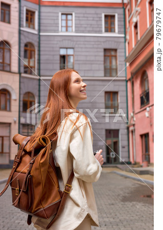 Portrait of tourist redhead woman taking photo of architecture on retro film camera Portrait of tourist redhead woman taking photo of architecture on retro film camera 79679747