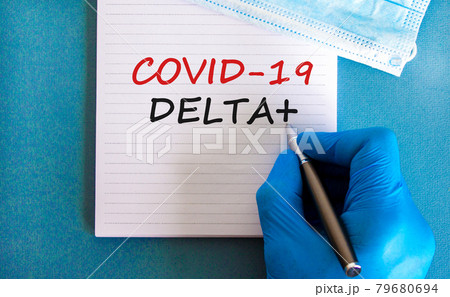 Covid-19 delta plus variant strain symbol. Hand in blue glove with white card. Concept words Covid-19 delta plus variant. Metalic pen. Medical, COVID-19 delta plus variant strain concept. Copy space. 79680694