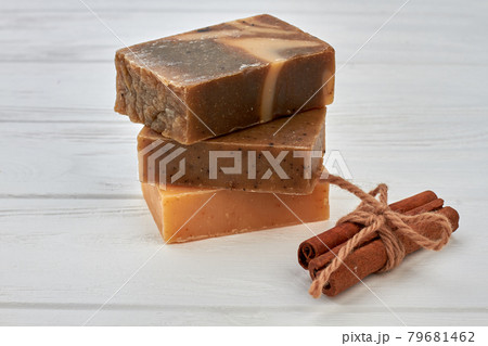 Stack of handmade soap blocks with cinnamon on white desk. 79681462