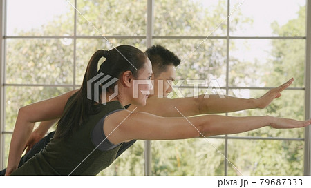 family couple doing YOGA standing meditating on virabhadrasana 3 pose workout 79687333