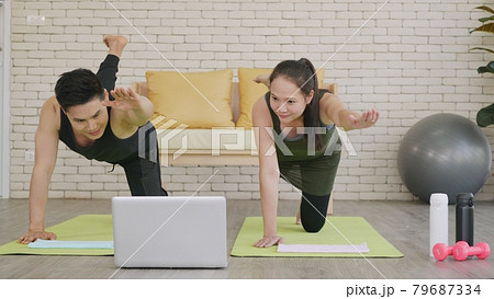 family couple doing YOGA standing meditating on virabhadrasana 3 pose workout 79687334