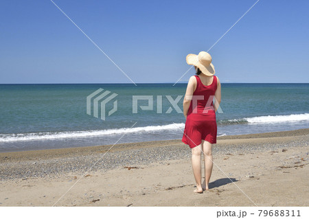 夏の北海道江差町五厘沢海岸でストローハットと赤いワンピースの女性のポートレートを撮影 79688311