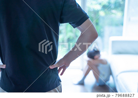 うずくまって泣く少女とそれを見る大人の様子 79688827