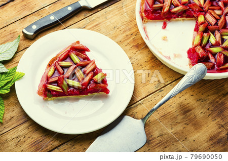 Pie with rhubarb and raspberries on old wooden background 79690050