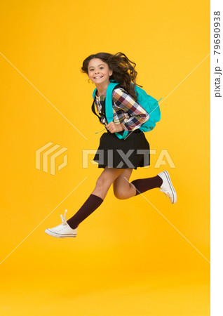 Moving with haste. Energetic child in midair yellow background. 79690938