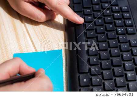 Hands Pressing Computer Keyboard Keys While Writing With Pencil In Notepad. Palms Typing Notebook Keypad And Writing Pencil Over Paper. 79694501