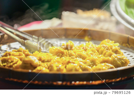 Close up fresh boiled dumplings with hot steams on wood plate Close up fresh boiled dumplings with hot steams on wood plate 79695126