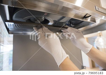 レンジフードの金属製フィルターを交換する男性手元 79695183