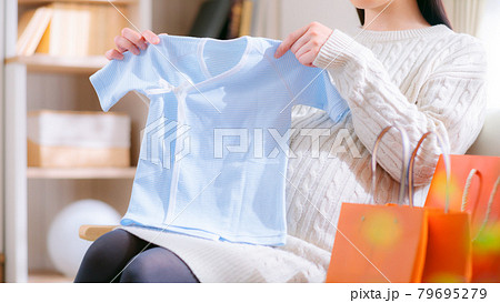 肌着を持つ妊婦　出産準備　買い物　おさがり　16:9 79695279