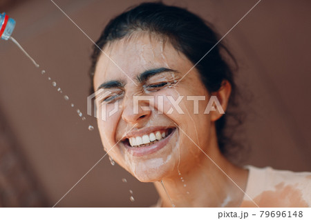 Stressed woman suffering of heatstroke refreshing with cold water outside. Weather abnormal heat concept. Stressed woman suffering of heatstroke refreshing with cold water outside. Weather abnormal heat concept. 79696148