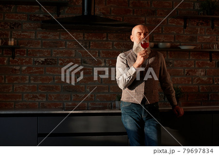 handsome man looking at the red wine in his glass . handsome man looking at the red wine in his glass . 79697834