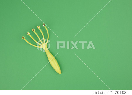 manual green plastic head massager with metal balls on green background manual green plastic head massager with metal balls on green background 79701889