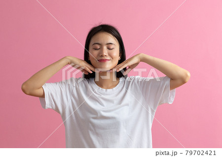 Close up portrait of young asian woman doing facebuilding yoga face gymnastics yoga massage 79702421