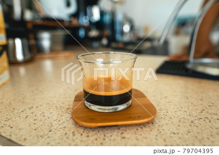 Ecfresso coffee from a press machine into a mug 79704395