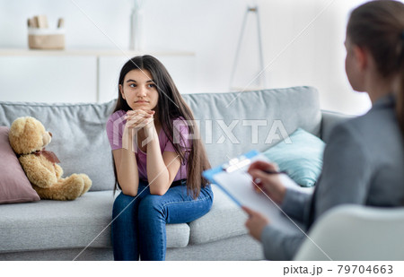 Female psychologist consulting depressed Indian teenage girl at office Female psychologist consulting depressed Indian teenage girl at office 79704663