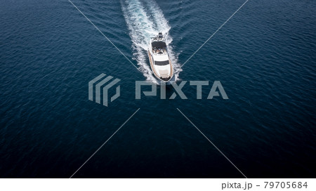 Aerial view of luxury speedboat yacht cruising in deep ocean water. Aerial view of luxury speedboat yacht cruising in deep ocean water. 79705684