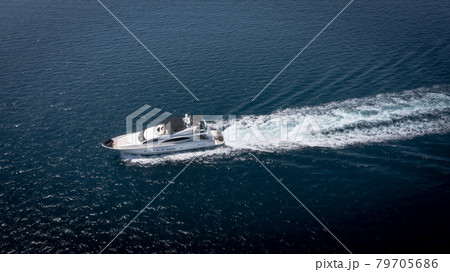 Aerial view of luxury speedboat yacht cruising in deep ocean water. Aerial view of luxury speedboat yacht cruising in deep ocean water. 79705686