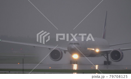 Airplane of Aeroflot taxiing on wet tarmac in the rain 79708125