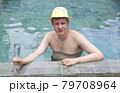 happy young man in hat at pool with cocktail 79708964