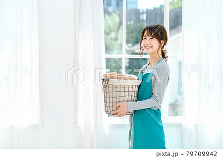 家で家事をするエプロン姿の若い主婦(洗濯) 家で家事をするエプロン姿の若い主婦(洗濯) 79709942