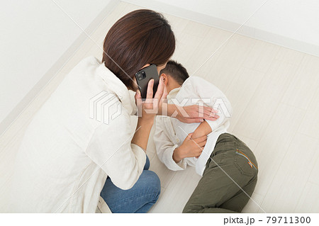 痛がる子供と緊急連絡する母親 79711300
