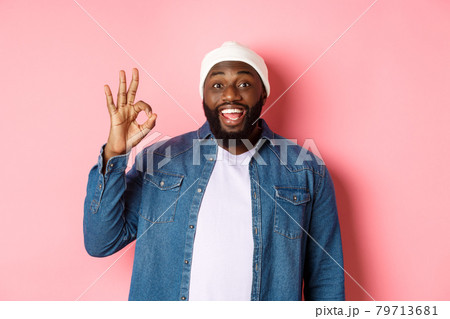 Happy smiling Black guy showing okay sign, approve and praise good offer, standing over pink background 79713681