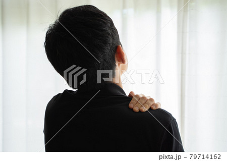 肩に手を置き窓辺に立つ男性の後ろ姿 肩に手を置き窓辺に立つ男性の後ろ姿 79714162