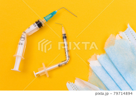 Broken Medical Syringe and Torn Medical Face Mask Broken Medical Syringe and Torn Medical Face Mask 79714894