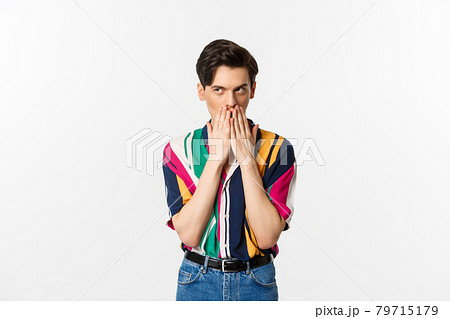 Image of cunning young man looking at upper left corner, scheming something, standing over white background 79715179